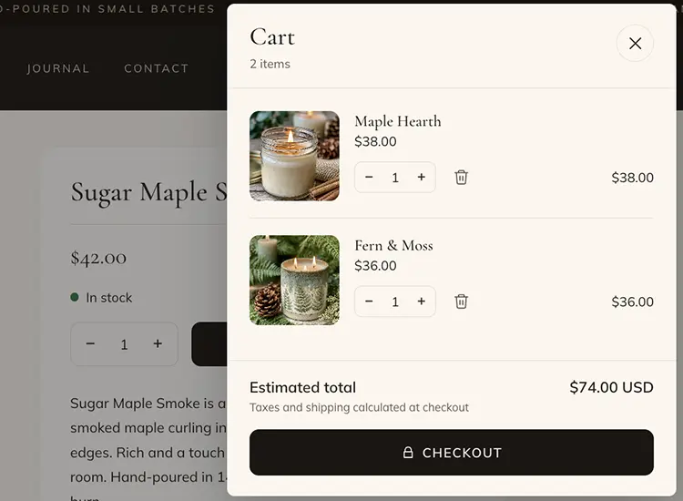 The cart sliding out over a candle's product page: two candles with quantity steppers, an estimated total of $74.00 with taxes and shipping calculated at checkout, and a Checkout button.
